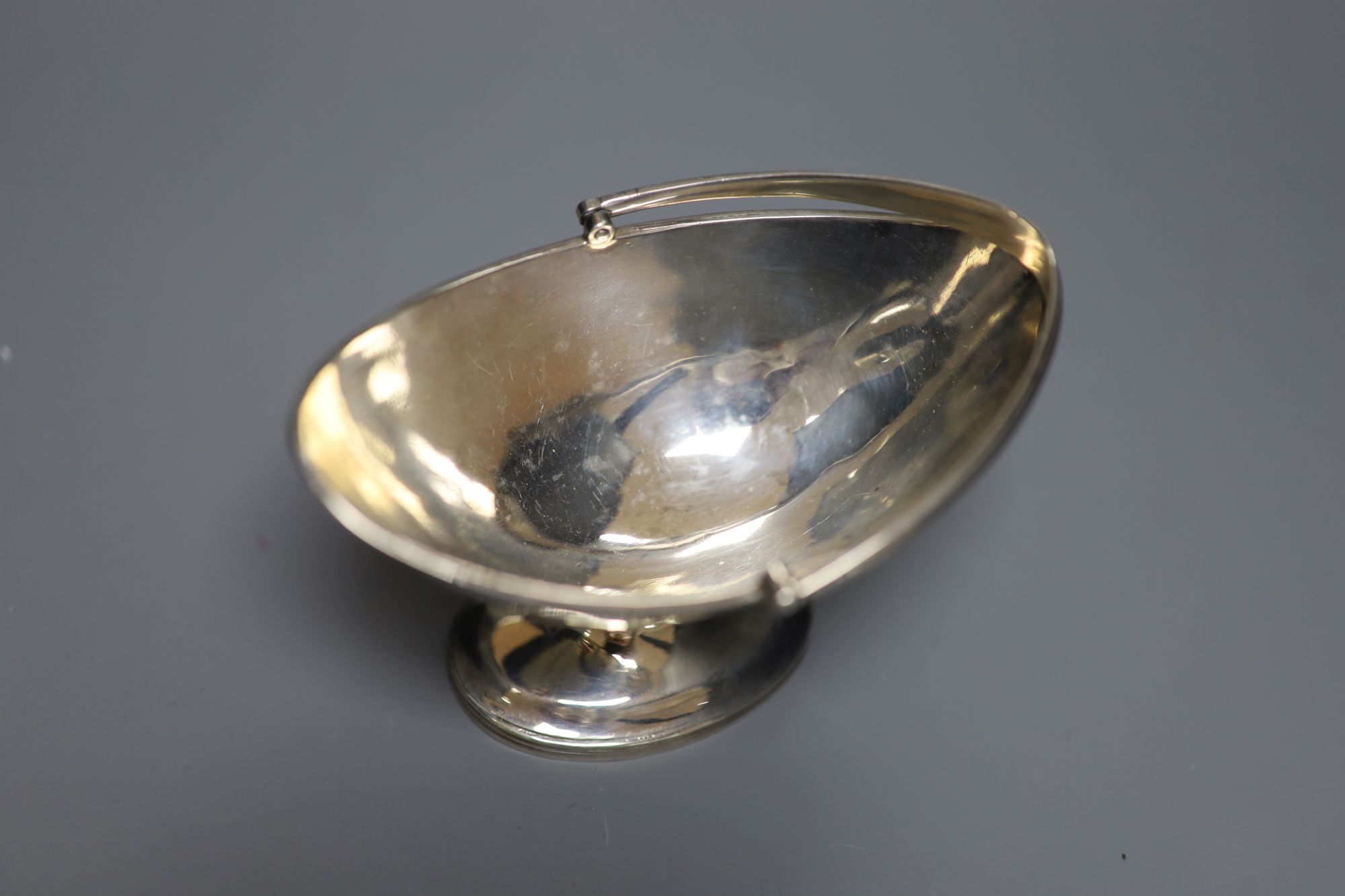 A small George III silver basket, London, 1785, a pair of Victorian silver peppers and a pair of later silver toastracks, 6.5oz.